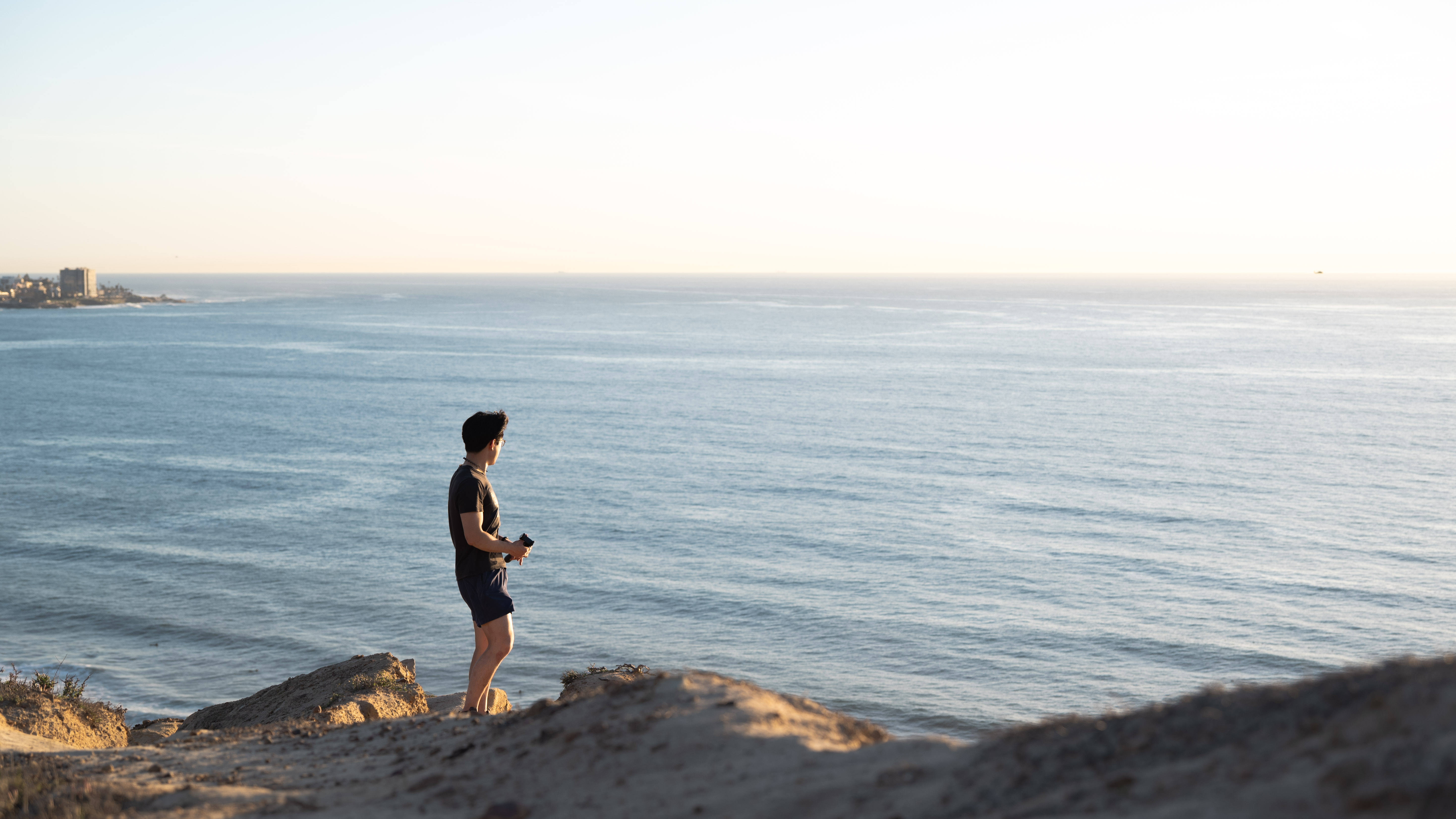 Nathan Fang standing by the ocean at sunset